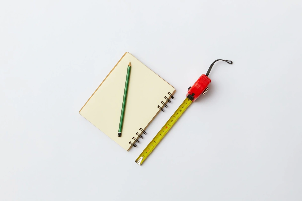 Carnet de relevé et mètre posés sur une table de chantier