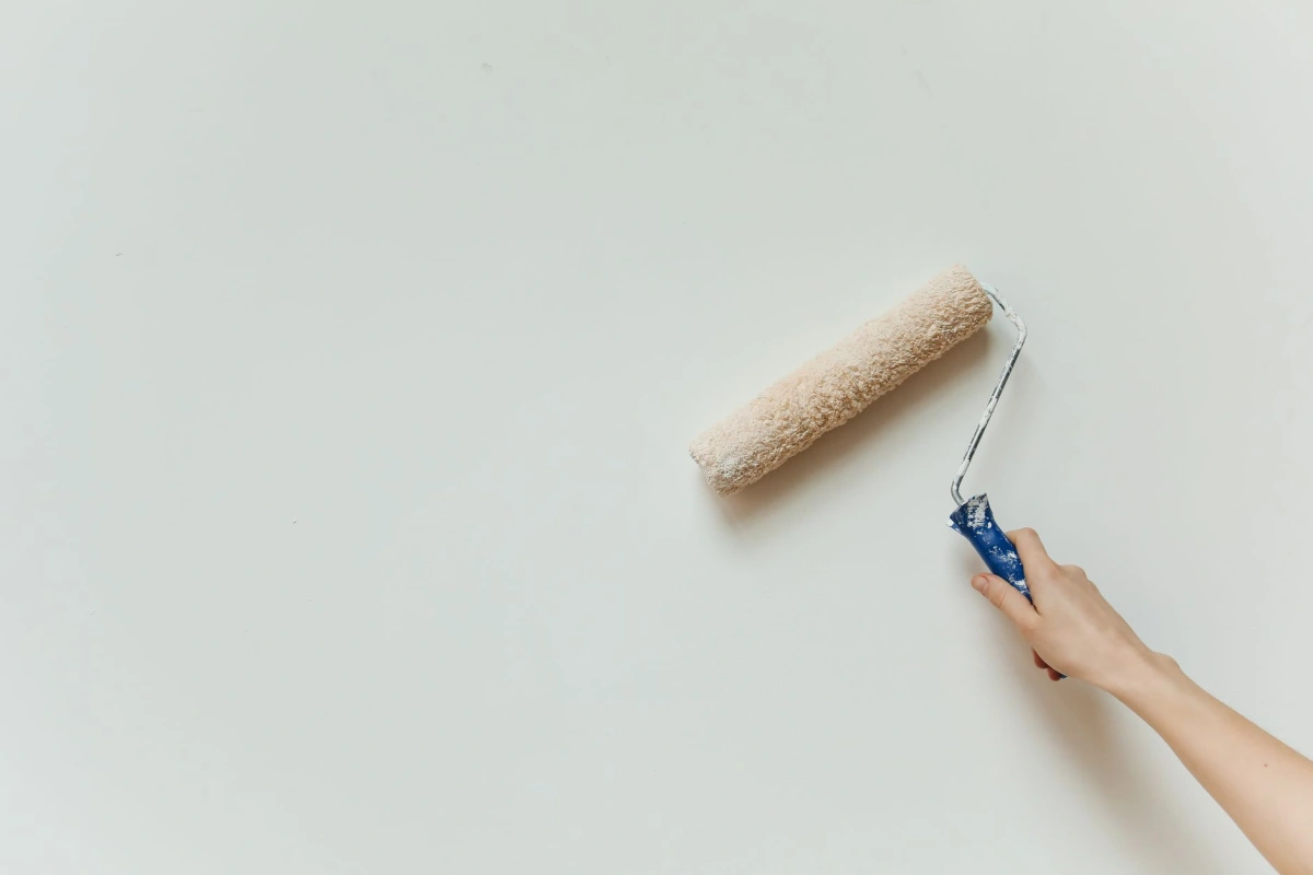 Application d'une peinture claire au rouleau sur un mur intérieur